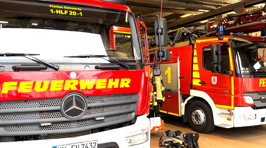 Zwei rote Feuerwehrwagen der Feuerwehr Schwerte stehen geparkt in einer Feuerwehrgarage.